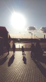 People in city against sky during sunset