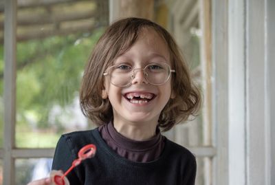 Portrait of cheerful boy wearing eyeglasses at home