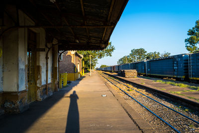 Shadow of person on railroad station platform