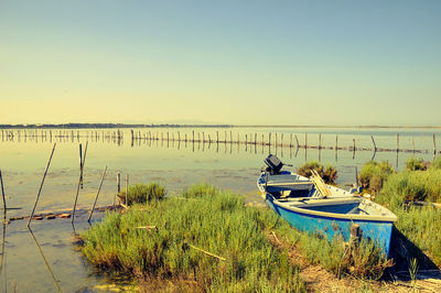 Boats moored in lake against clear sky