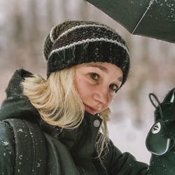 Close-up of woman holding umbrella during snow fall