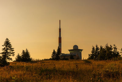 Built structure on field against sky during sunset
