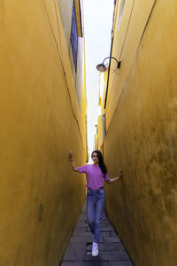 Rear view of woman standing in tunnel