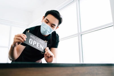 Portrait of man standing by window