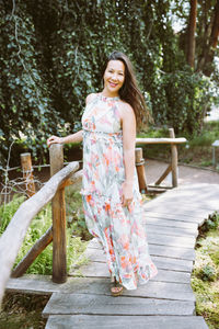 Happy mixed-race japanese woman in romantic floral maxi dress in park