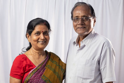 Portrait of an aged indian couple smiling on white background