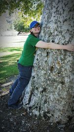 Portrait of a smiling young man on tree trunk