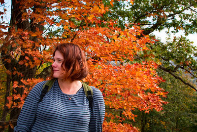 Woman standing against trees in forest