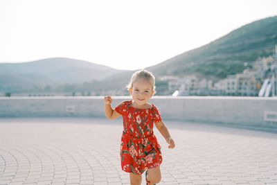 Portrait of cute girl standing against lake