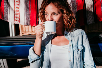 Mid section of woman with coffee cup