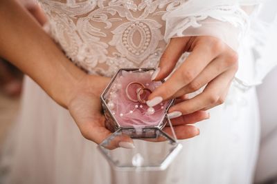 Midsection of bride holding rings in jewelry box during wedding ceremony 