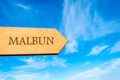 Low angle view of information sign against blue sky