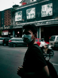 Rear view of man standing on street in city