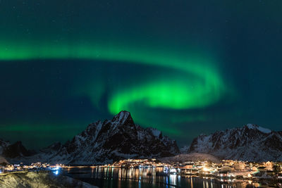 Scenic view of illuminated snowcapped mountains against sky at night