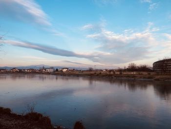 Scenic view of lake by city against sky