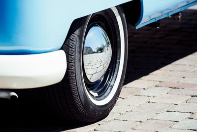 Cropped image of car parked on street during sunny day