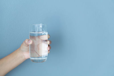 Hand holding glass of water