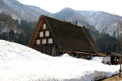 Snow covered landscape and mountains against sky