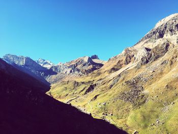 Scenic view of mountains against clear blue sky