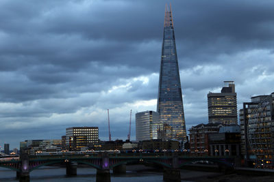 Low angle view of modern buildings against cloudy sky