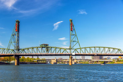 Hawthorne bridge over willamette river against blue sky in city