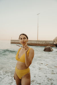 A girl on the beach with a yellow bikini