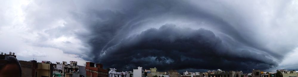 Panoramic view of city against dramatic sky