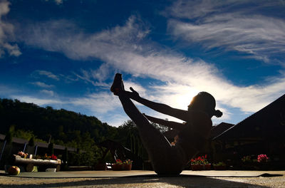 Silhouette people relaxing in city against sky