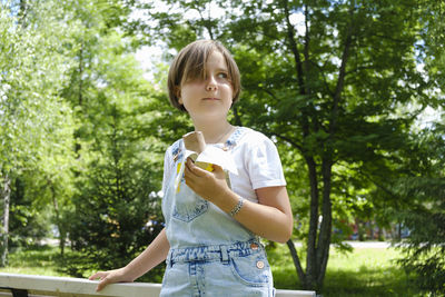 Teenage girl on a walk on a summer day in the park to enjoy ice cream