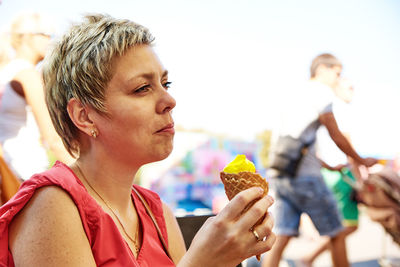 Close-up of woman eating food against sky