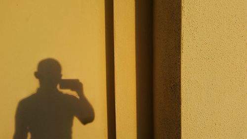 Shadow of man on yellow wall