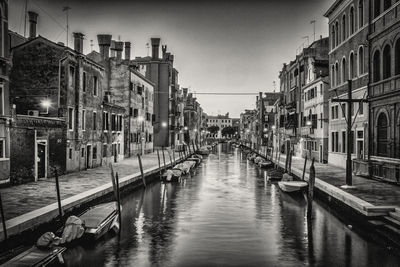 Canal amidst buildings against sky in city