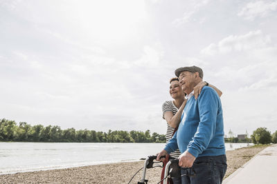 Senior man and his daughter standing at riverside