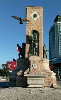 Low angle view of statue in city against clear sky