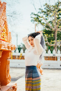 Woman looking away while standing outdoors