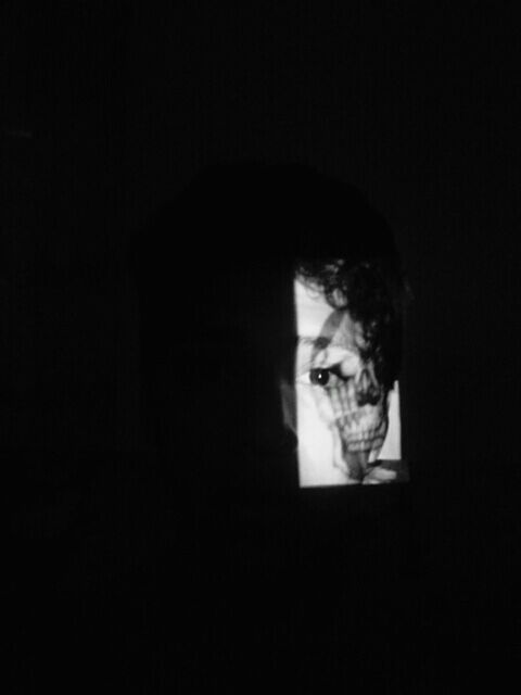 indoors, studio shot, black background, copy space, dark, headshot, portrait, looking at camera, darkroom, young adult, front view, close-up, lifestyles, young men, human face, contemplation, serious, leisure activity