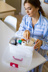 Young woman looking down while sitting in kitchen