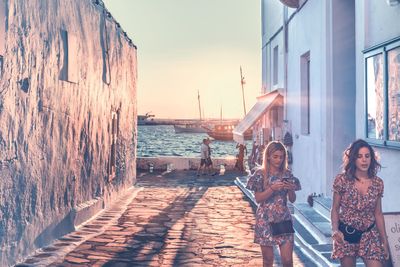 People standing at sea shore against sky