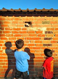 Two boys looking the snout of a horse