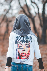 Portrait of woman standing against tree