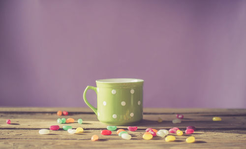 Close-up of candies and cup on table