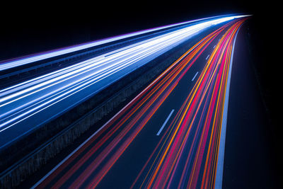 Light trails on illuminated city road at night