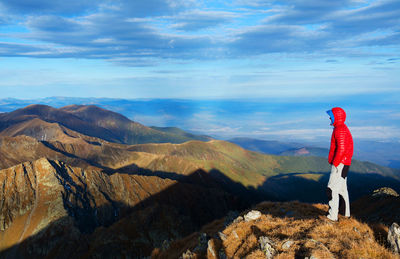 View of man standing on mountain against sky