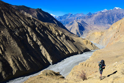 Hiker walking on mountain during sunny day