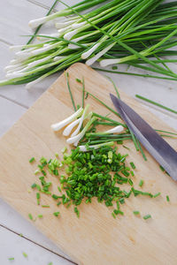 High angle view of scallions on cutting board over table