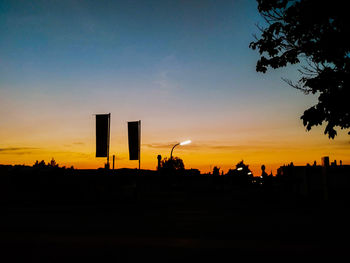 Silhouette city against sky during sunset