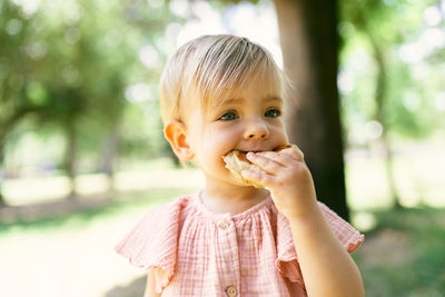 Cute girl eating food sitting outdoors