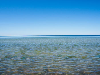 Scenic view of sea against clear blue sky