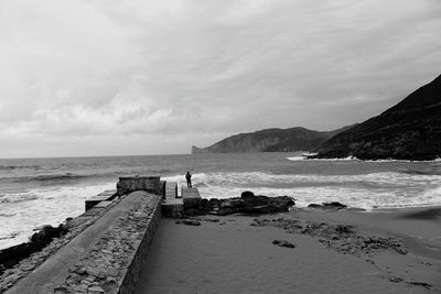 Man fishing in sea against sky