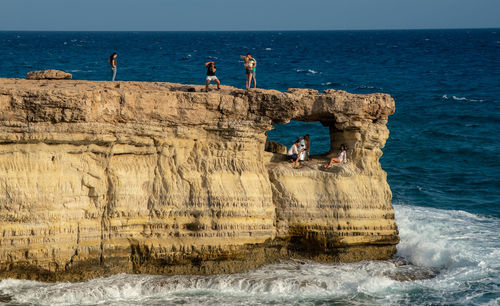 Group of people on rock at beach